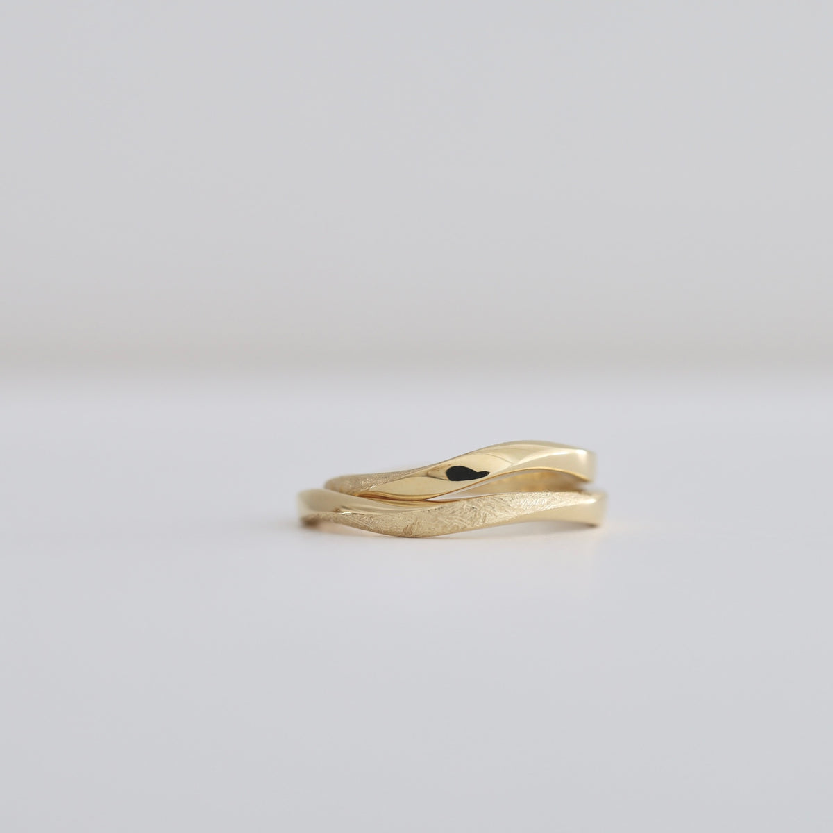 S字に滑らかにうねる動きのデザイン Sラインツイスト K18イエローゴールドのマリッジリング（結婚指輪） 鏡面仕上げにレザー加工