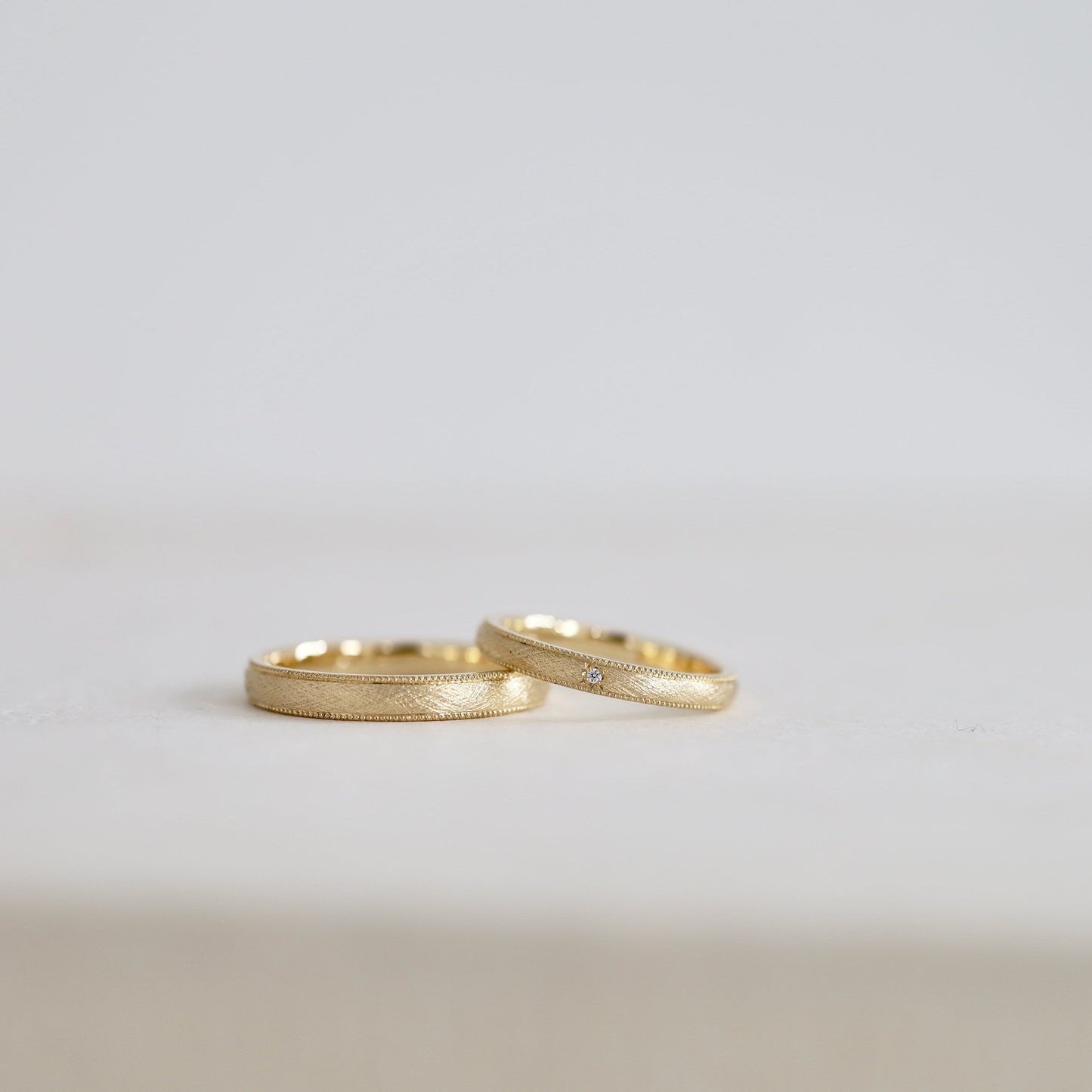 両側にミルグレイン加工を入れた麻布のようなテクスチャーが入ったゴールドの結婚指輪/ateliertamari（アトリエタマリ）大阪心斎橋・京都のオーダーメイドリング